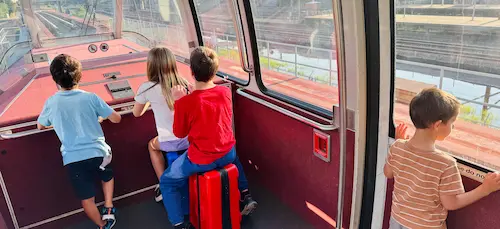 Kids on the Newark Airport AirTrain with their packed suitcases