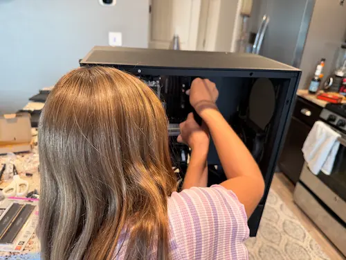My daughter connecting a power supply to the motherboard